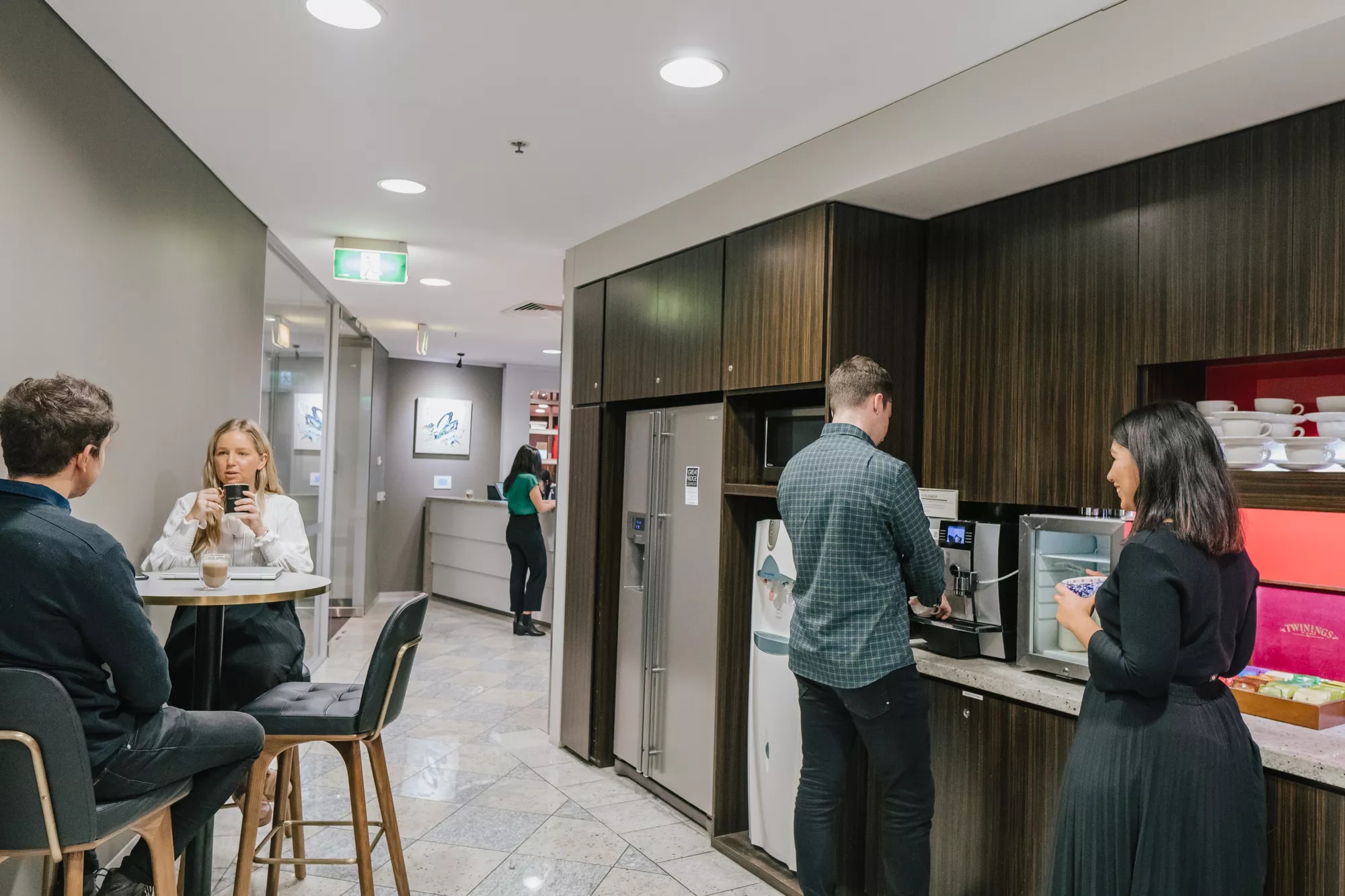Clients in a modern coworking space enjoying fully stocked kitchen in Servcorp Southbank, Melbourne