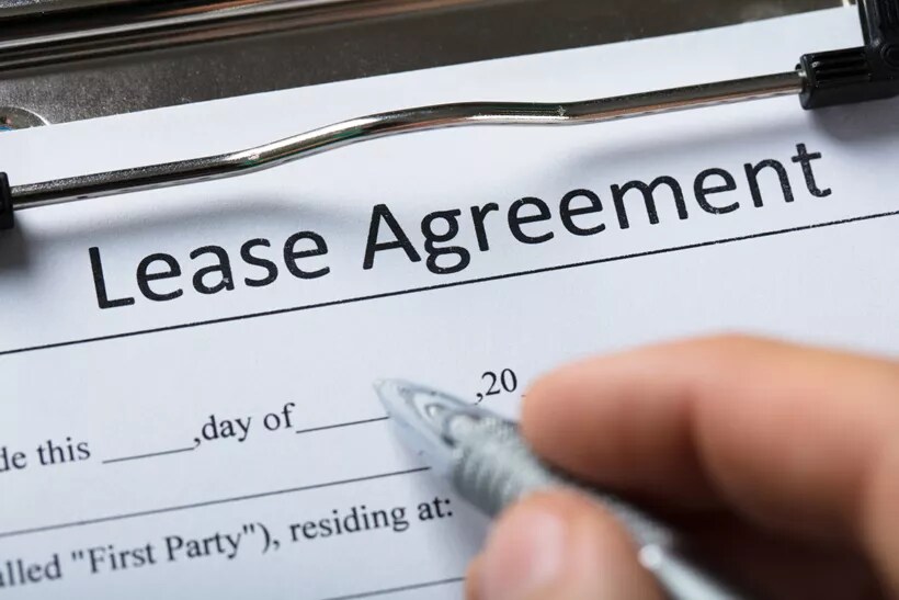 Using a pen to sign a lease agreement document