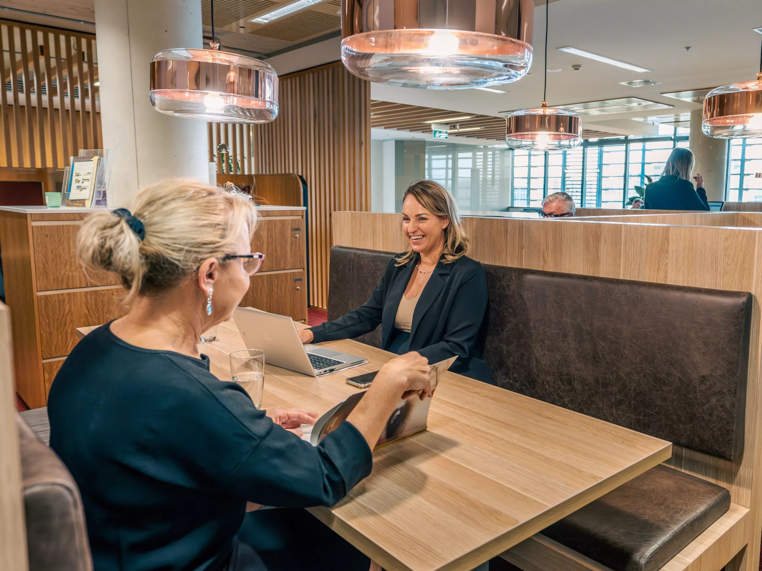 Close up on clients working in a modern coworking space, in Servcorp Nishi Building, Canberra