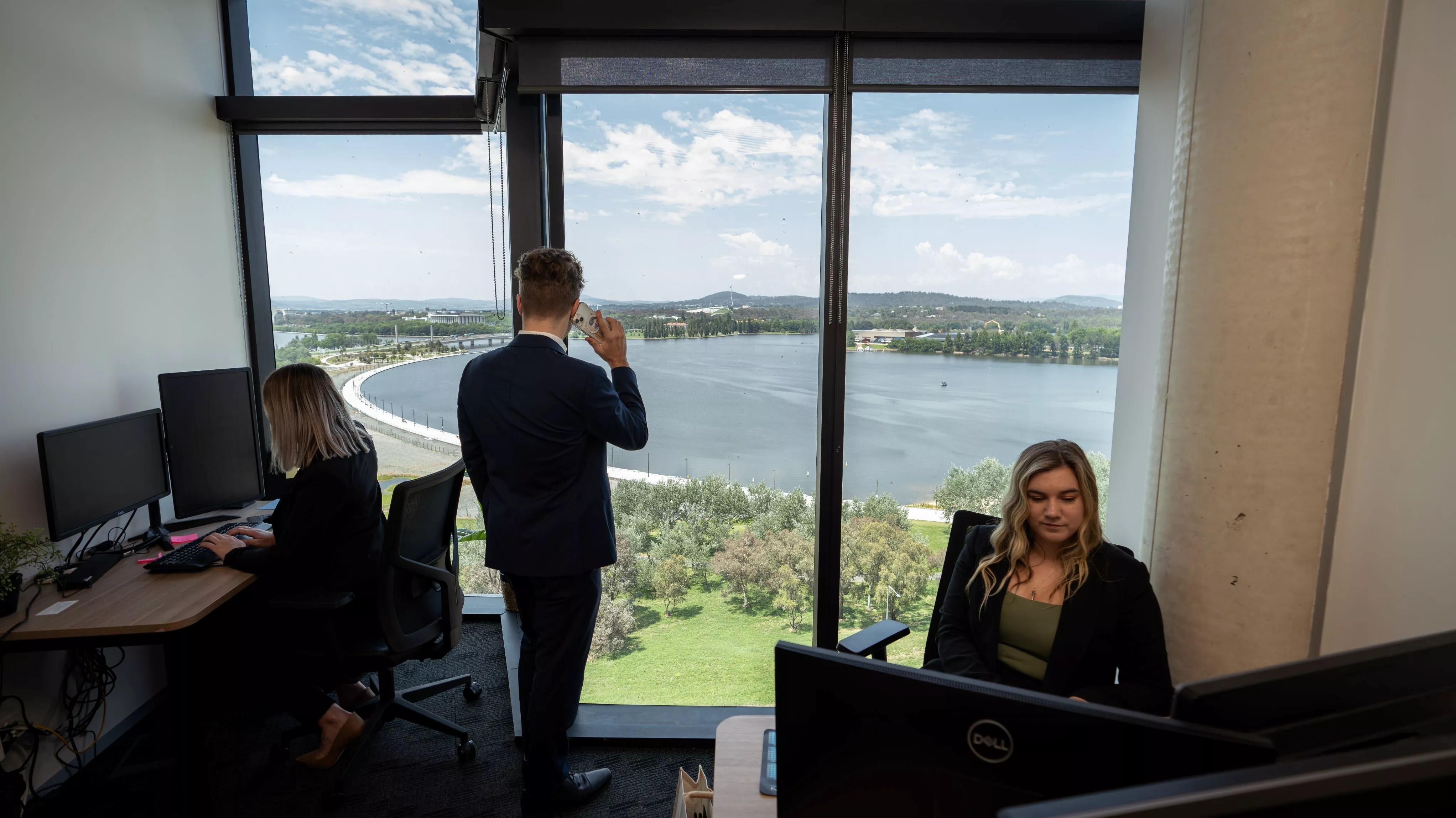 Client receiving IT help from a specialist over the phone in a modern serviced office in Servcorp Nishi Building, Canberra