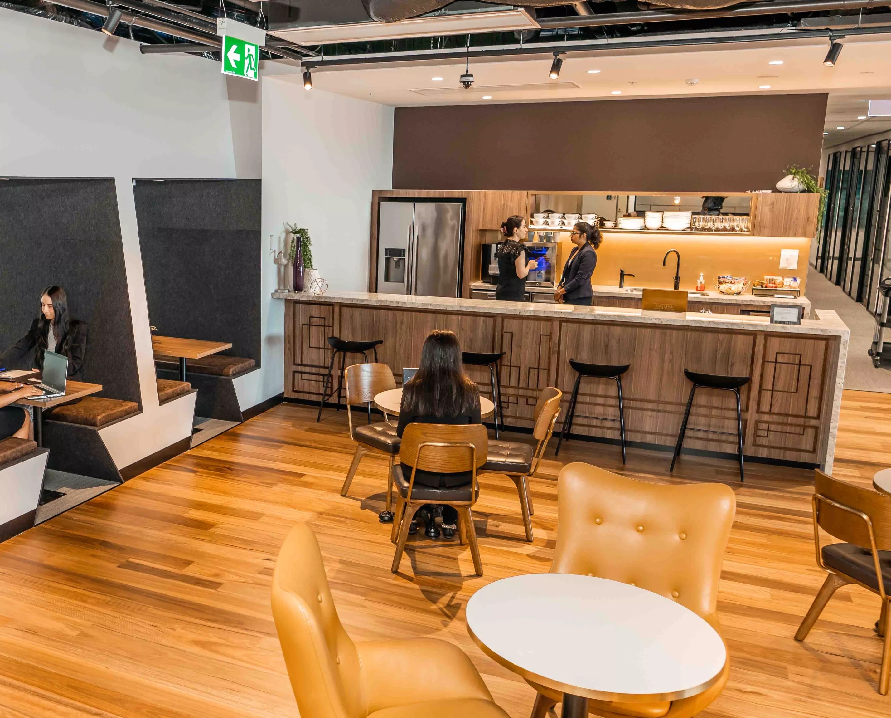 People enjoying their time in a modern coworking space lounge and fully stocked kitchen break room in Servcorp 100 Mount Street