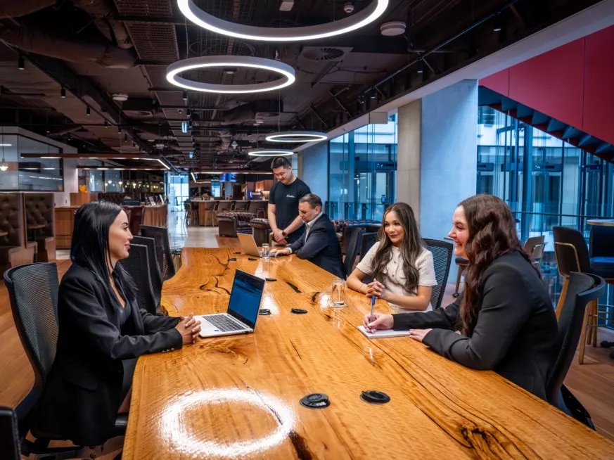 Clients working in a modern coworking room space on a large table in Servcorp 3 Parramatta Square