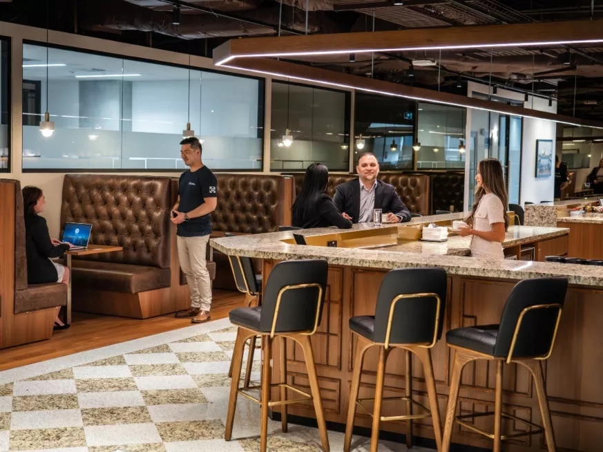 Clients working in the booths and modern fully stocked kitchen of a modern coworking space within Servcorp 3 Parramatta Square