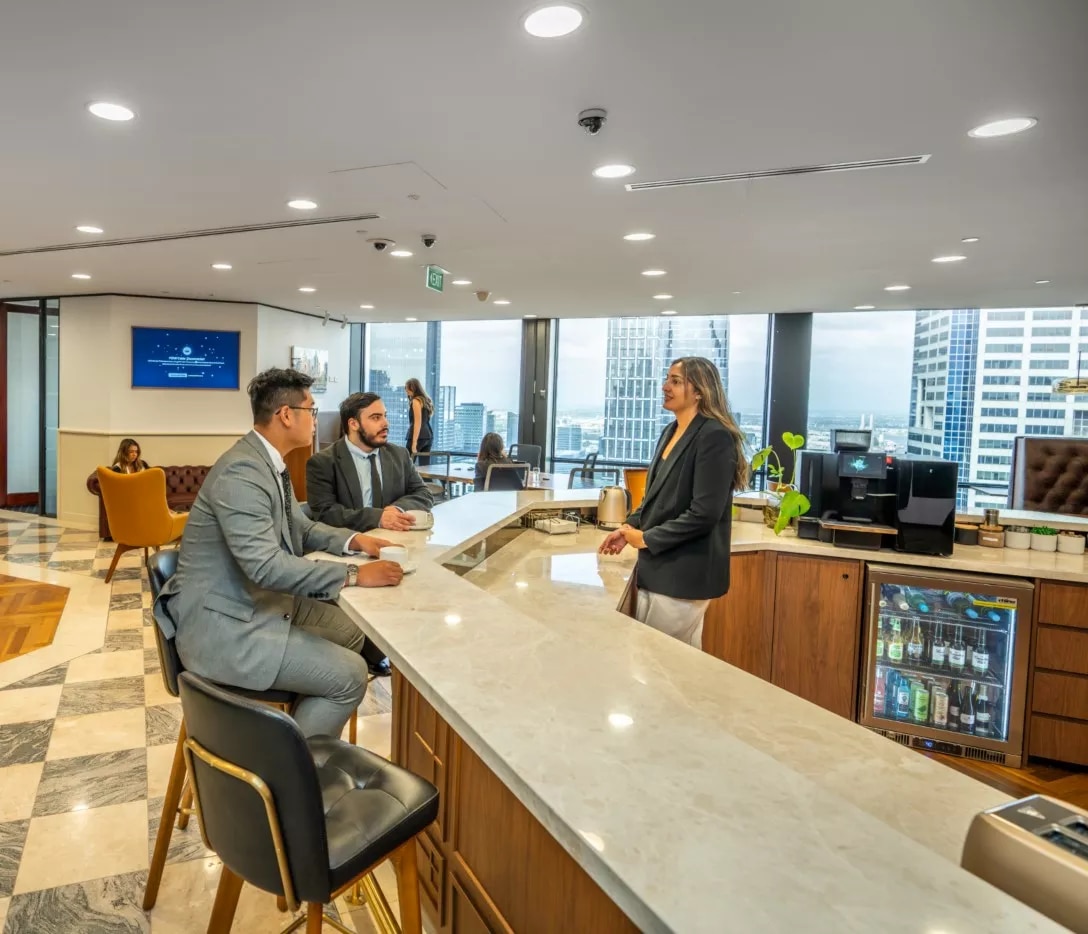Close up on clients in a modern coworking space enjoying fully stocked kitchen in Servcorp 140 William, Melbourne